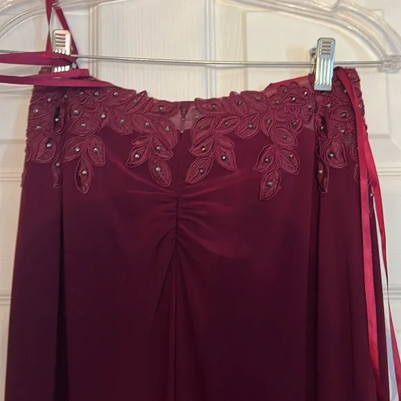 This prom dress is Burgundy, a size 2 with corset straps in the back. Worn once
